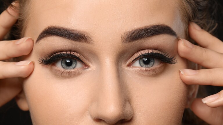 Close-up of natural-looking filled eyebrows with defined arches and soft eye makeup.