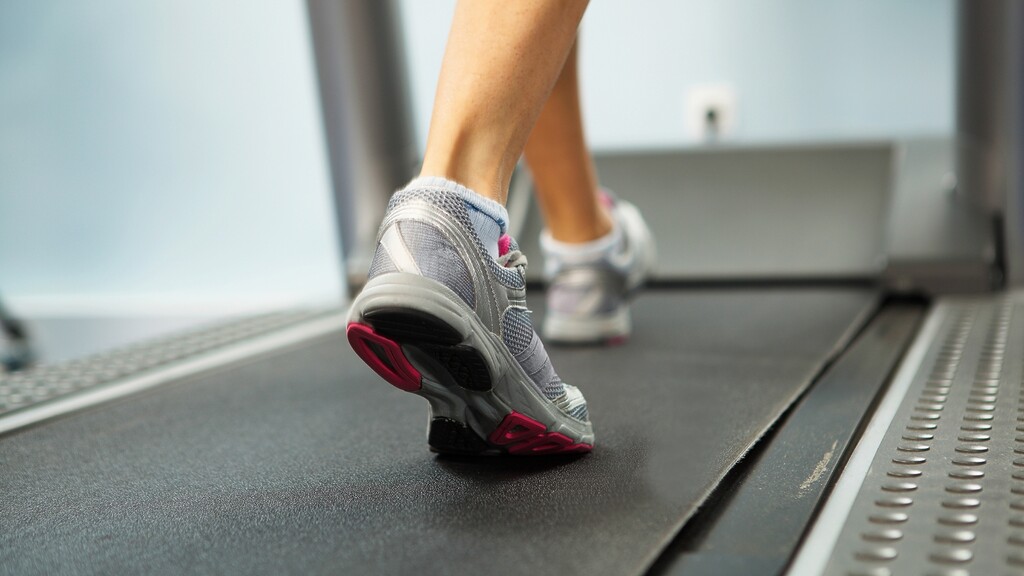 Close-up of a person walking on a treadmill during a low-impact cardio workout.