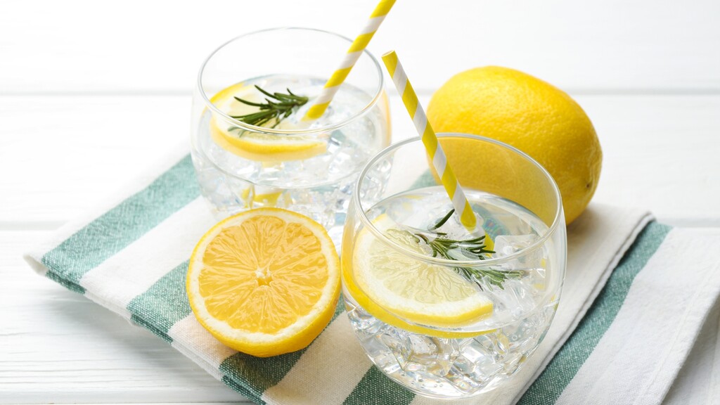 Glasses of lemon water with ice, rosemary, and fresh lemon slices.