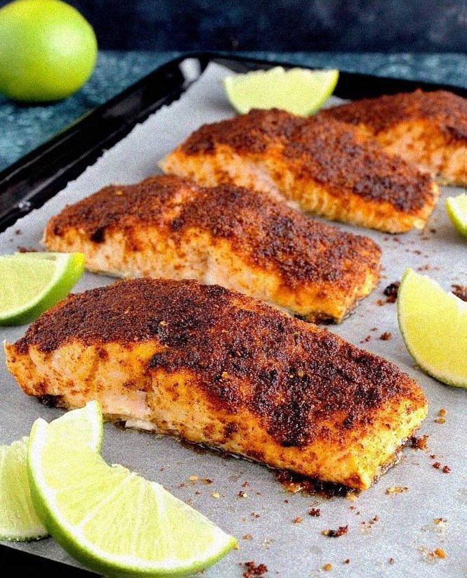 Plated chili lime baked salmon with a dark caramelized spice crust and fresh lime slices