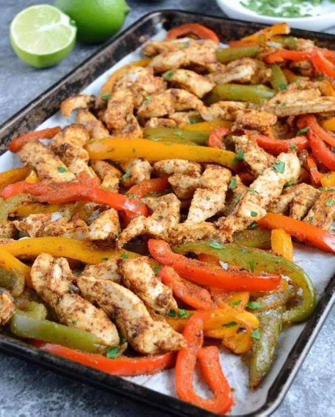roasted low sodium chicken fajitas on a parchment lined baking sheet with vibrant sliced bell peppers and fresh cilantro