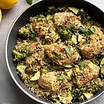 A deep skillet filled with seared chicken breast, fluffy quinoa, bright green broccoli, and zucchini tossed in fresh lemon basil